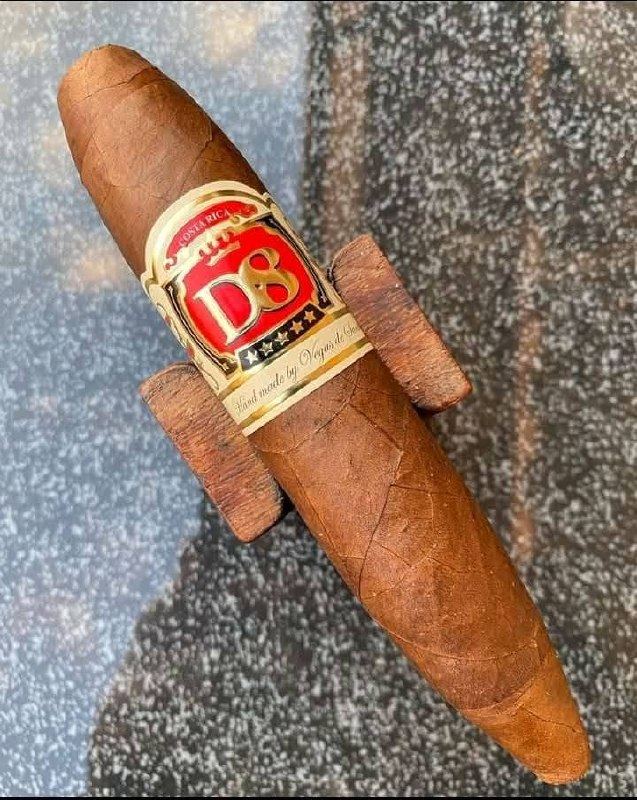 A cigar resting on a wooden stand, band visible