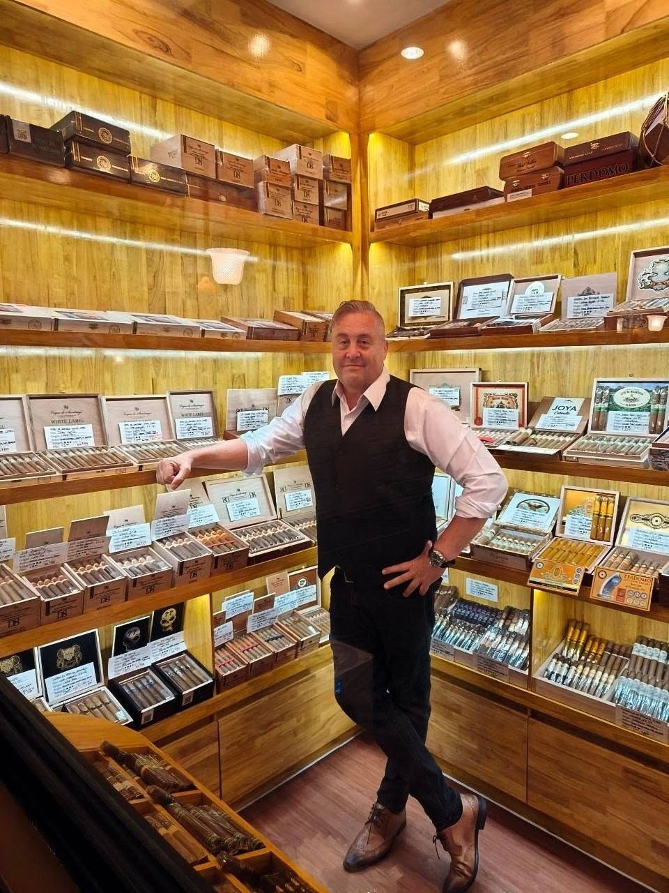 Inside the walk-in humidor at Cigar Connection, wooden shelves lined with boxes of cigars
